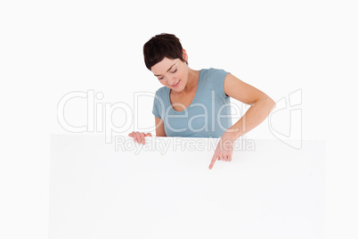 Brunette woman pointing at something on a panel