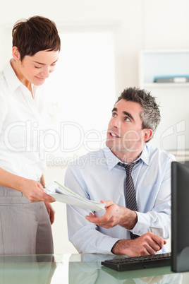 Portrait of secretary giving a document to her manager
