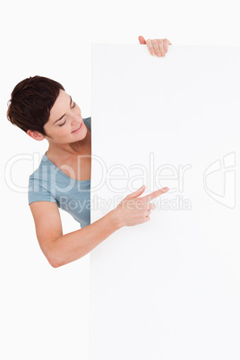 Smiling brunette looking at a blank panel