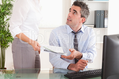 Manager receiving a document from his secretary