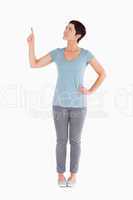Dark-haired woman pointing at copy space