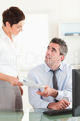 Portrait of a manager receiving a document from his secretary
