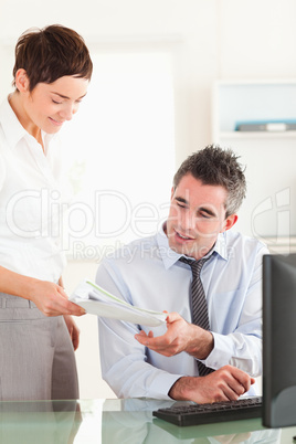 Portrait of a manager receiving a document from his employee