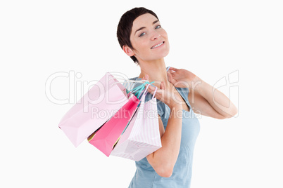 Dark-haired woman posing with shopping bags