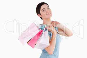 Dark-haired woman posing with shopping bags