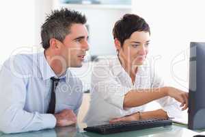 Businesswoman showing something on a screen to her colleague