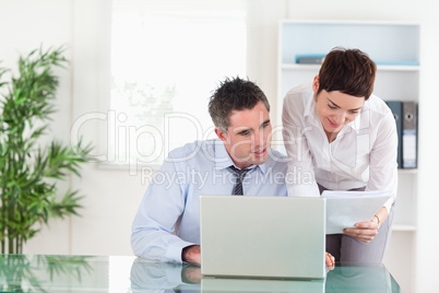 Colleagues comparing a blueprint document to an electronic one