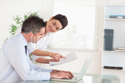 Office workers comparing a blueprint folder to an electronic one