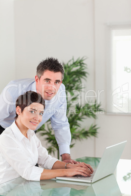 Portrait of a manager and his secretary posing with a laptop