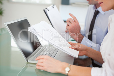 Managers comparing a blueprint document to an electronic one