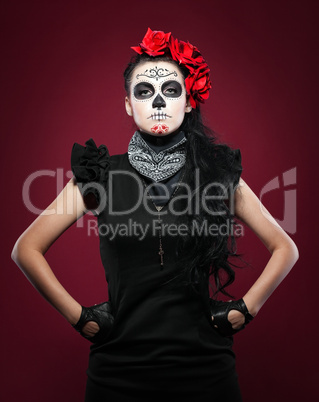 Young girl in day of the dead mask on red