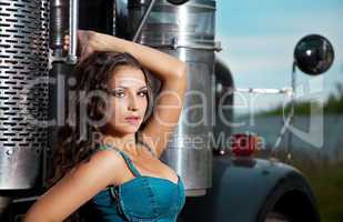 Young pretty girl in jeans stand near steel truck