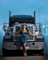 Young pretty girl posing before huge cargo truck