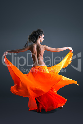 Beauty girl with naked spine dance in orange cloth