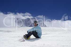 Snowboarder resting on the ski slope