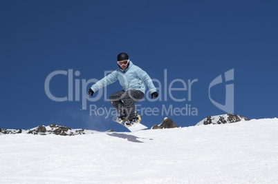 Snowboarder jumping in the mountains