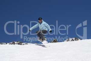 Snowboarder jumping in the mountains