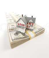 Small House on Row of Hundred Dollar Bill Stacks