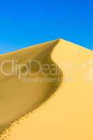 sand dunes over blue sky