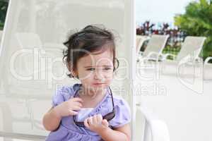cute toddler girl in summer clothes and sunglasses