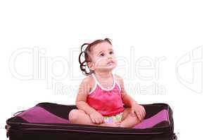 cute little girl sitting on the black suitcase