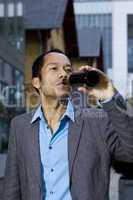 Smart casual business man drinking beer outdoors portrait in front of modern office building