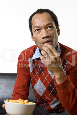 Man nibbling while watching television