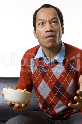 Man nibbling while watching television