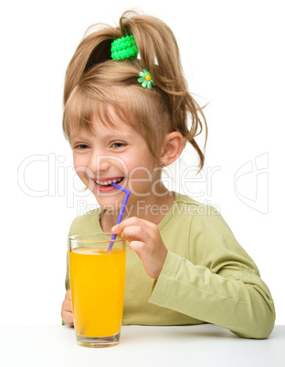 Cute little girl is drinking orange juice