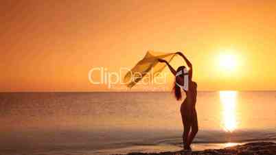 silhouette of young woman in a bikini at sunset