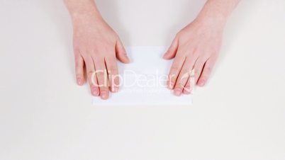 Folding a sheet of paper up.