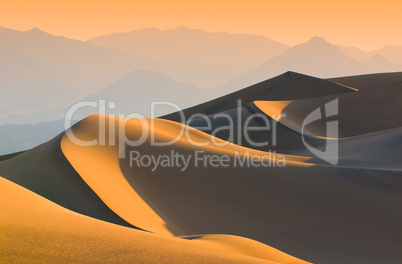 sand dunes over sunrise sky