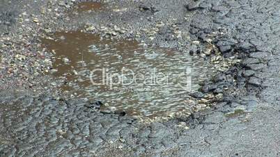 puddle in the potholes on the road during rain