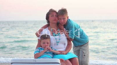 Family walks on the beach at sunset