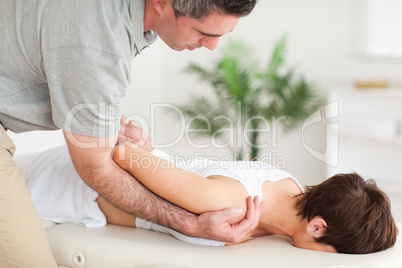 Brunette woman getting a shoulder-stretching