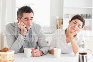 Exhausted couple drinking coffee