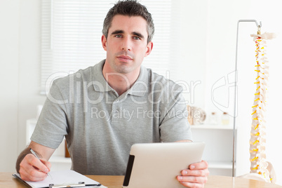 Male Doctor working with a tablet and a chart