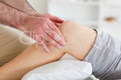 Man massaging a lying woman's knee