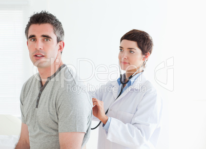 Doctor examining her patient with a stethoscope