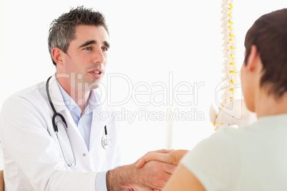 Male Doctor greeting a female patient
