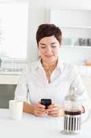 Woman with coffee looking to her mobile phone