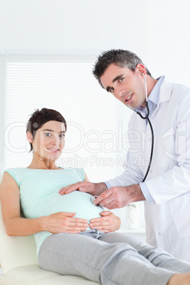 Doctor examining a pregnant woman with a stethoscope