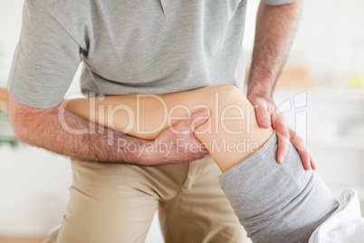 Chiropractor massaging a woman's knee