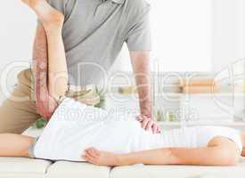 Chiropractor is stretching a woman's leg