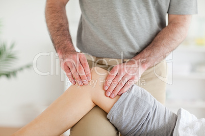 Male Chiropractor massaging a charming woman's knee