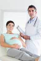 Doctor and pregnant patient looking at the camera