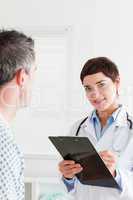 Doctor talking to a male patient while holding a chart