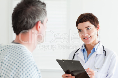 Doctor talking to a male patient holding a chart