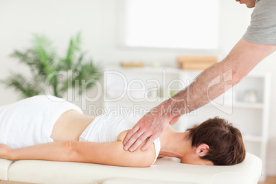 Masseur massaging woman's back