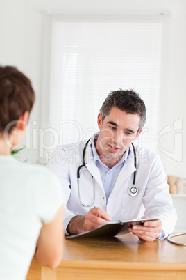 Handsome Doctor talking to a brunette patient